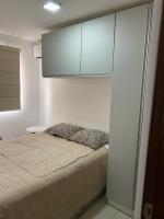 a bedroom with a bed with white walls and cabinets at Residencial Havaí in João Pessoa