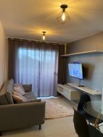 a living room with a couch and a flat screen tv at Residencial Havaí in João Pessoa