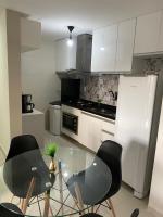 a kitchen with a glass table and black chairs at Residencial Havaí in João Pessoa