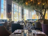 麦克尔斯菲尔德斯林格利厅酒店的餐厅里有桌椅和窗户。