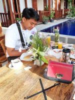 un homme assis à une table avec une assiette de nourriture dans l'établissement Wait Garden Cottage, à Nusa Penida