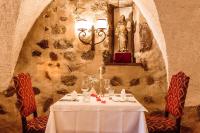 a table in a restaurant with a statue of a woman at Hotel Castel Rundegg (Adults Only) in Merano