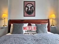 a bedroom with a bed with a netflix inclusive online login sign at Landlust Hotel in Gransee