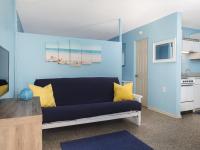 ein blaues Wohnzimmer mit einem Sofa und einer Küche in der Unterkunft South Beach Inn - Cocoa Beach in Cocoa Beach