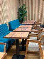 a row of wooden tables and chairs in a room at Hotel Guzy in Lier