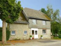 a large brick house with a white door at Holiday Home with Garden Heating Barbecue in Butgenbach