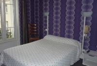 a bedroom with a white bed and a purple wall at Ardenn&#39;Hotel in Reims
