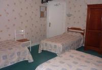 a hotel room with two beds and a cabinet at Ardenn&#39;Hotel in Reims