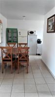a living room with a table and a kitchen at Casa na praia da Pinheira in Palhoça