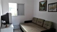 a living room with a couch and a television at Casa na praia da Pinheira in Palhoça