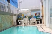 Un patio con mesa y sillas junto a una piscina. en Rede Andrade Jangadeiro, en Aracaju