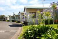 a row of houses on a street with purple flowers at Discovery Parks - Warrnambool in Warrnambool