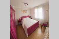 a bedroom with a large bed with a pink frame at Entre parc et Haras in Hennebont