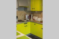 a kitchen with bright yellow cabinets and green counters at Entre parc et Haras in Hennebont