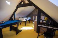 a room with a piano and a desk in a attic at Entre parc et Haras in Hennebont