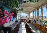 una sala de estar con sofás y ventanas en un edificio en Gudeok Guesthouse, en Seogwipo