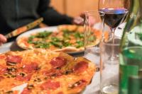 two pizzas sitting on a table with a glass of wine at Appartement Wildspitz' in Vent