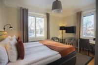 1 dormitorio con 1 cama, escritorio y 2 ventanas en Park Hotell, en Kristinehamn