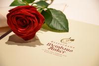 Hotel & Weinhaus Anker في ماركت هايدنفلد: وردة حمراء موضوعة فوق بطاقة تهنئة