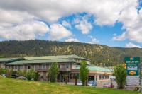 Un gran edificio con una montaña al fondo. en Sandman Hotel &amp; Suites Williams Lake, en Williams Lake