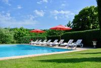 a group of chairs and umbrellas next to a pool at Domaine Leyvinie, gite Mourvedre, close to the Dordogne in Perpezac-le-Blanc