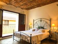 a bedroom with a bed and a large window at Sas Tilibbas-Ammentos Posada in Posada