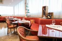 a restaurant with a red couch and tables and chairs at Etrusco Arezzo Hotel - Sure Hotel Collection by Best Western in Arezzo