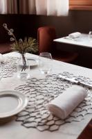 a table with a white table cloth with plates and glasses at Hotel Tremoggia in Chiesa in Valmalenco