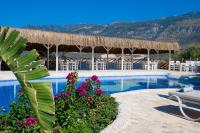 un resort con piscina con sedie e fiori di Peninsula Gardens Hotel a Kaş