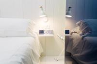 a bedroom with a bed and a nightstand with lights at Atypik Hotel in Clichy