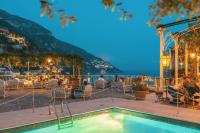 a restaurant with a pool and a view of the ocean at Hotel Poseidon in Positano