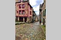 an alley in an old town with a red building at T2 situé au cœur du centre historique de Dinan in Dinan