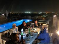 ルクソールにあるNile Panorama Hotel & Restaurantの夜にテーブルに座って夕食を食べている人々のグループ