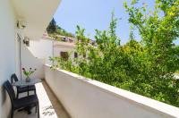 a balcony with two chairs and a view of a garden at Rooms &amp; Apartments Barišić in Mlini