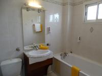 a bathroom with a sink and a tub and a toilet at Hôtel Résidence Le Phoenix in Saint-Pierre