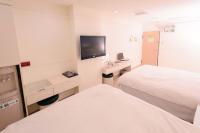 a hotel room with two beds and a flat screen tv at Kiwi Express Hotel - Zhong Zheng Branch in Taichung