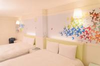 a bedroom with two beds and a painting on the wall at Kiwi Express Hotel - Zhong Zheng Branch in Taichung