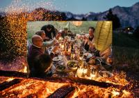 um grupo de pessoas sentadas à volta de uma mesa com comida em Maiensässhotel Guarda Val em Lenzerheide