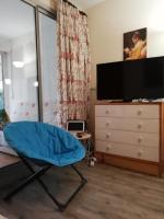 a bedroom with a blue chair and a dresser at Appartement avec terrasse in Saint-Cyprien-Plage
