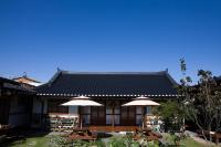 ein Gebäude mit Tischen und Sonnenschirmen davor in der Unterkunft Hanok Raon in Gyeongju
