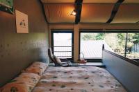 a bed in a room with a large window at Taipei Jinguashi Cloud Mountain Homestay B&amp;B in Jiufen