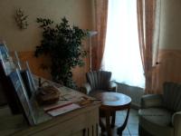 a living room with a tv and a table and chairs at Hôtel Emilie in Royan