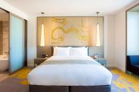 a bedroom with a large white bed and a blue chair at Crowne Plaza Vientiane by IHG in Vientiane