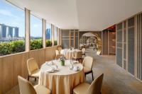 a restaurant with tables and chairs and windows at PARKROYAL COLLECTION Marina Bay, Singapore in Singapore