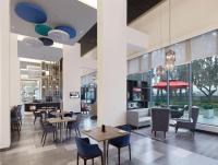 a restaurant with tables and chairs and windows at Holiday Inn Express Kolkata Airport by IHG in Kolkata