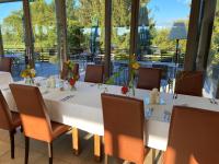 a dining room with a table and chairs and windows at Bachhof Resort Hotel in Straubing