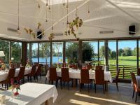 a dining room with tables and chairs and windows at Bachhof Resort Hotel in Straubing