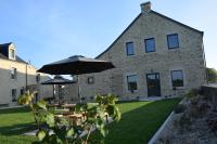 a patio with tables and an umbrella in front of a building at Domaine de kerbillec in Theix