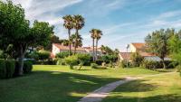 a park with palm trees and a path at Village Club Thalassa in Mèze