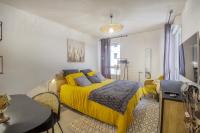 a bedroom with a yellow bed and a table at Voltaire in Toulouse